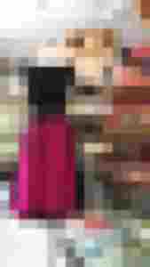 Schwarzes Kleid mit pinker Lodenschürze und schwarzem Bindegürtel auf Schneiderpuppe im Laden