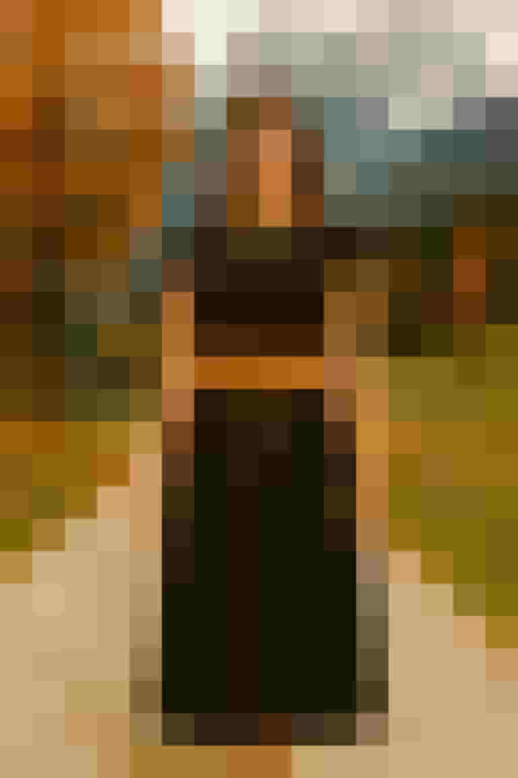 Frau in schwarzem Kleid mit braunem Gürtel auf Landweg