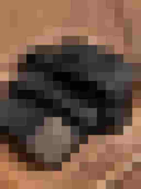 Schwarzer Gürtel aus recyceltem Kunstleder auf einem Holztablett.