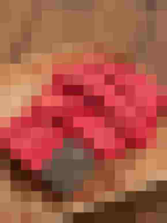 Roter Gürtel aus recyceltem Kunstleder auf einem Holztablett, Rockzipfl-Design.