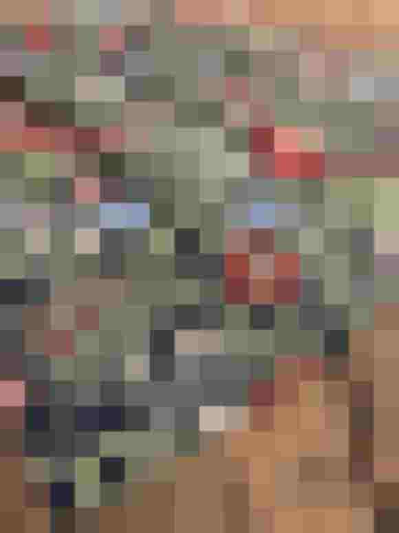 Bunte Baumwoll-Schürze mit floralen Mustern auf dunklem Hintergrund, ideal für festliche Anlässe.