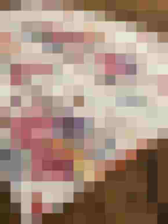 Bunte Baumwollschürze mit floralen und tierischen Mustern auf Holzoberfläche.