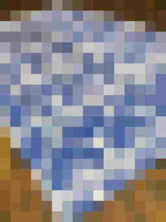 Blaue Schürze mit floralen Mustern auf rustikalem Holzuntergrund. Nachhaltige Mode aus Österreich.