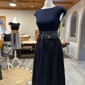 Schaufensterpuppe mit schwarzer Lurex-Spitzenschürze und Gürtel